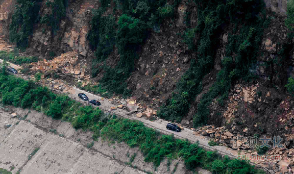 5月15日,一段通往汶川的道路被山体滑坡的巨石阻断,许多车辆