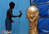 2014年6月9日， 2014年巴西世界杯前瞻：世界杯氛围日益浓厚 球迷街边制作大力神杯带梅西脸谱。...
