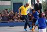高清图：哈里王子不回国 穿巴西球衣和小孩踢球